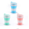 A set of reusable silicone collapsible coffee cups in various shades of blue and pink with lids.