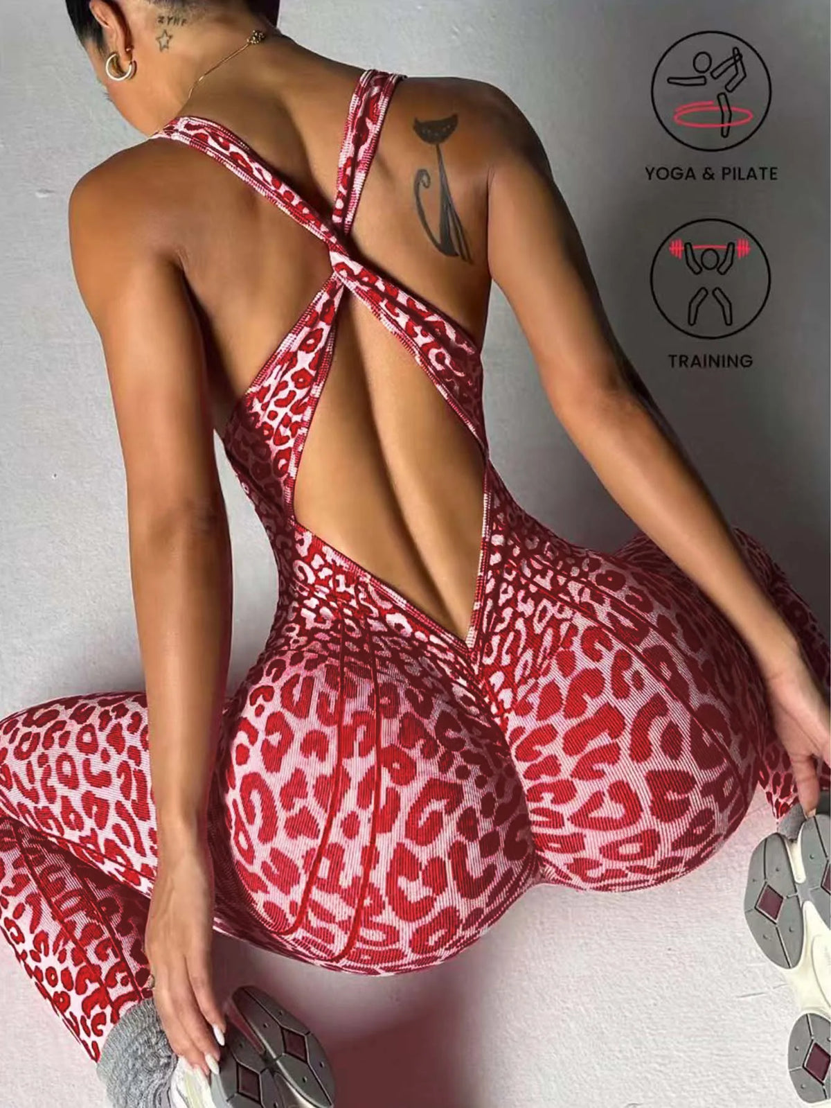 Femme portant une combinaison de yoga sans coutures à dos croisé à imprimé léopard rouge, posant dans un studio.