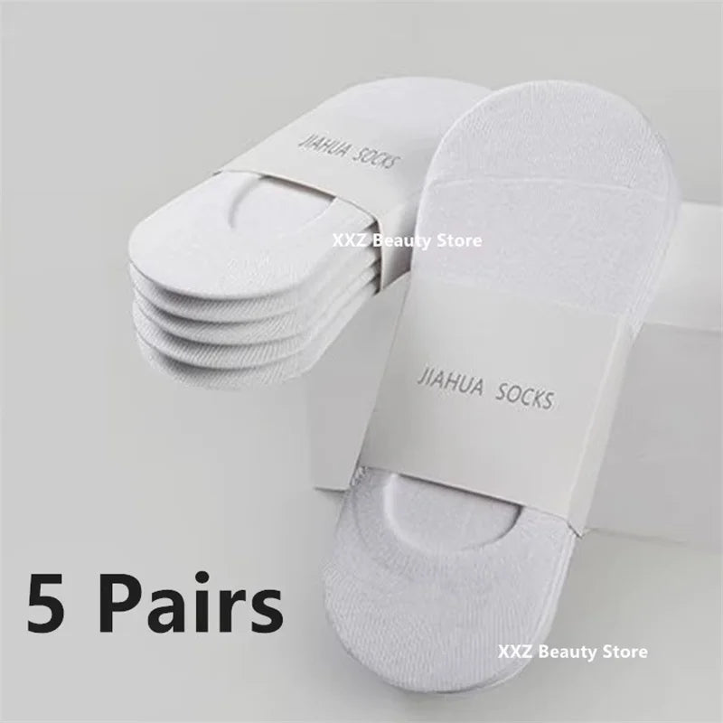 Five pairs of white invisible silicone no-show boat socks stacked on a white box.