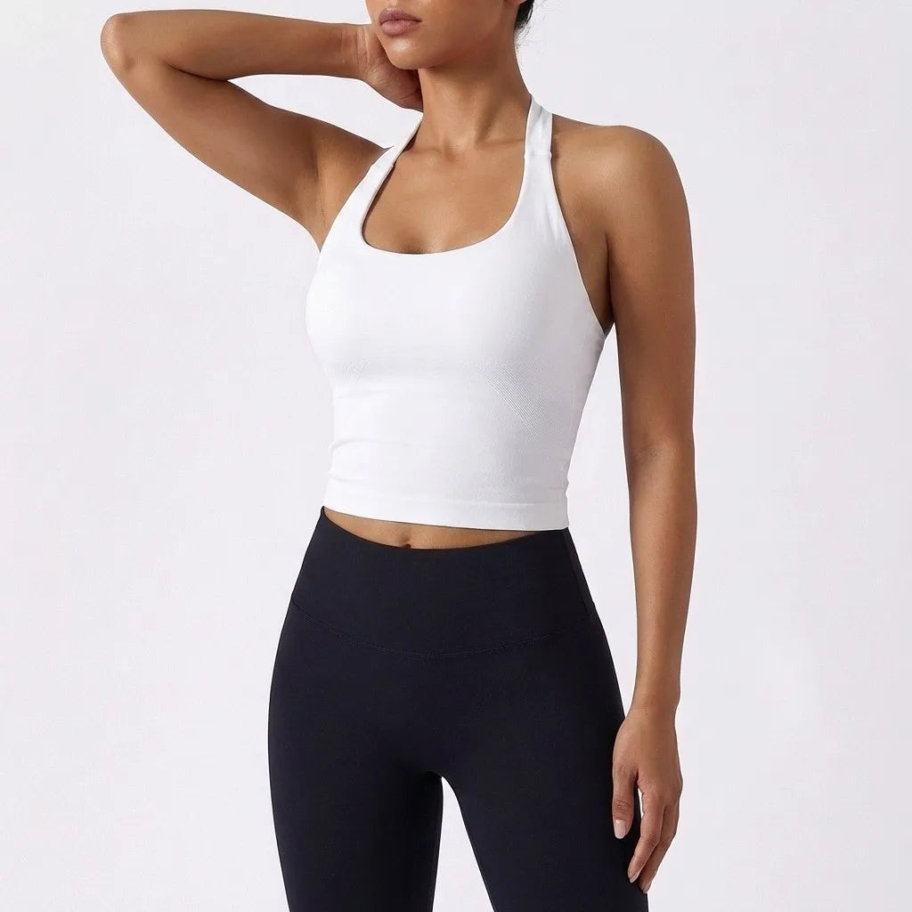 A model wearing a white seamless yoga sports bra and black leggings.
