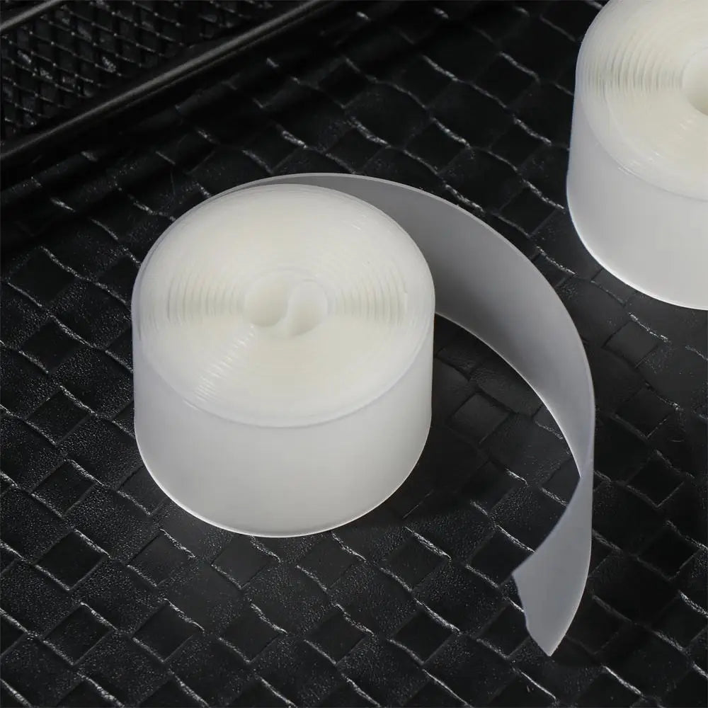 Un rollo de forro para neumáticos de bicicleta blanco para protección contra pinchazos, sobre una superficie negra texturizad