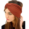 A woman wearing a rust-colored stretch sport headband on her hair.