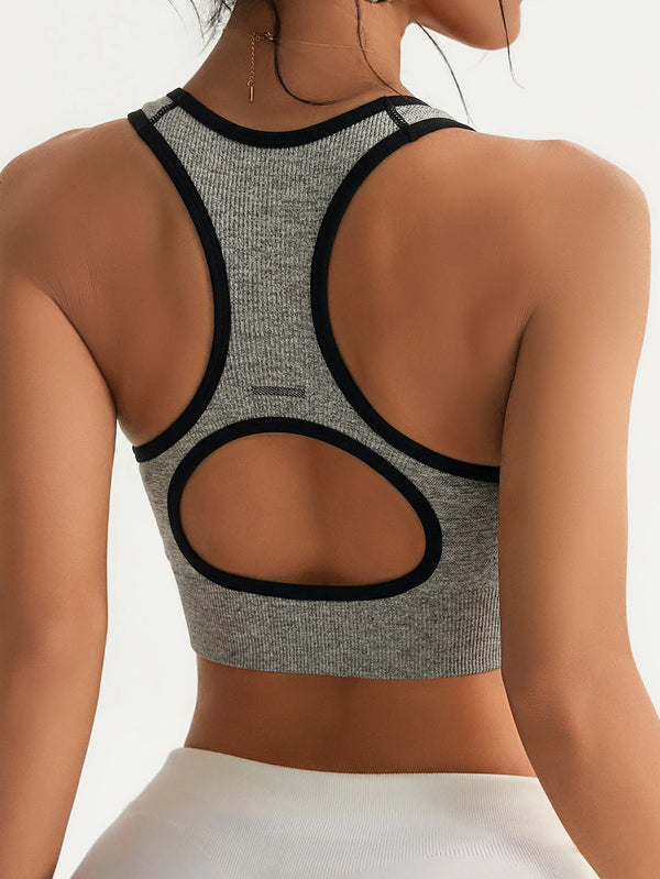 Graues Seamless Racerback Sport-BH mit schwarzem Zierrand und passender weißer Unterteil von hinten sichtbar.