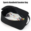 Black handheld sneaker bag with a zippered opening, holding a white and colored athletic shoe.