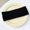 A black elastic hairband is placed diagonally across a light beige plate.