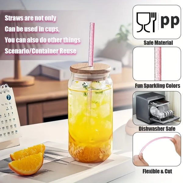 Ein Glas mit gelber Flüssigkeit und rosa Strohhalm neben Orangenscheiben