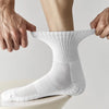 A close-up of a person putting on white breathable sports performance socks.