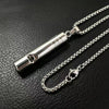 A silver stainless steel whistle pendant necklace for men displayed on a black leather surface.