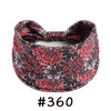 A close-up of a patterned, knotted cotton headband with a floral print in shades of pink and black.