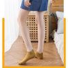 Una mujer viste un blazer azul y pantalones grises claros, mostrando calcetines amarillos para los tobillos.