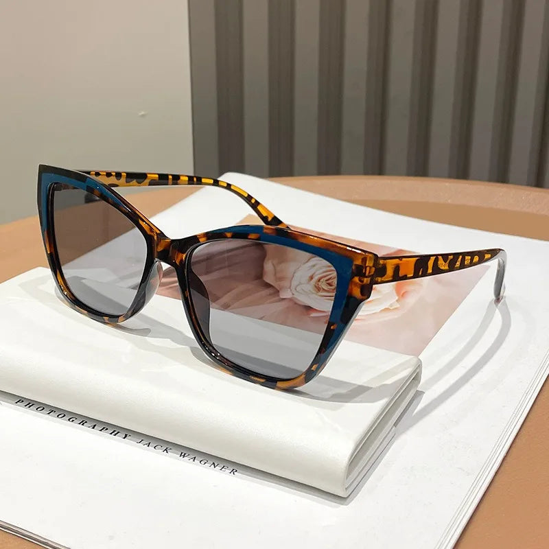 Vintage square cat eye sunglasses with tortoiseshell pattern resting on a white book.
