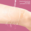 A close-up of a transparent body shaping patch being squeezed with water on human skin.