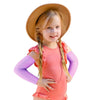 Una niña vistiendo mangas protectoras UV de color melocotón y un sombrero de paja.