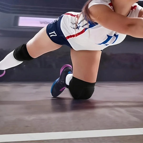 A woman wearing white and blue sports attire is performing a move while wearing black knee pads.