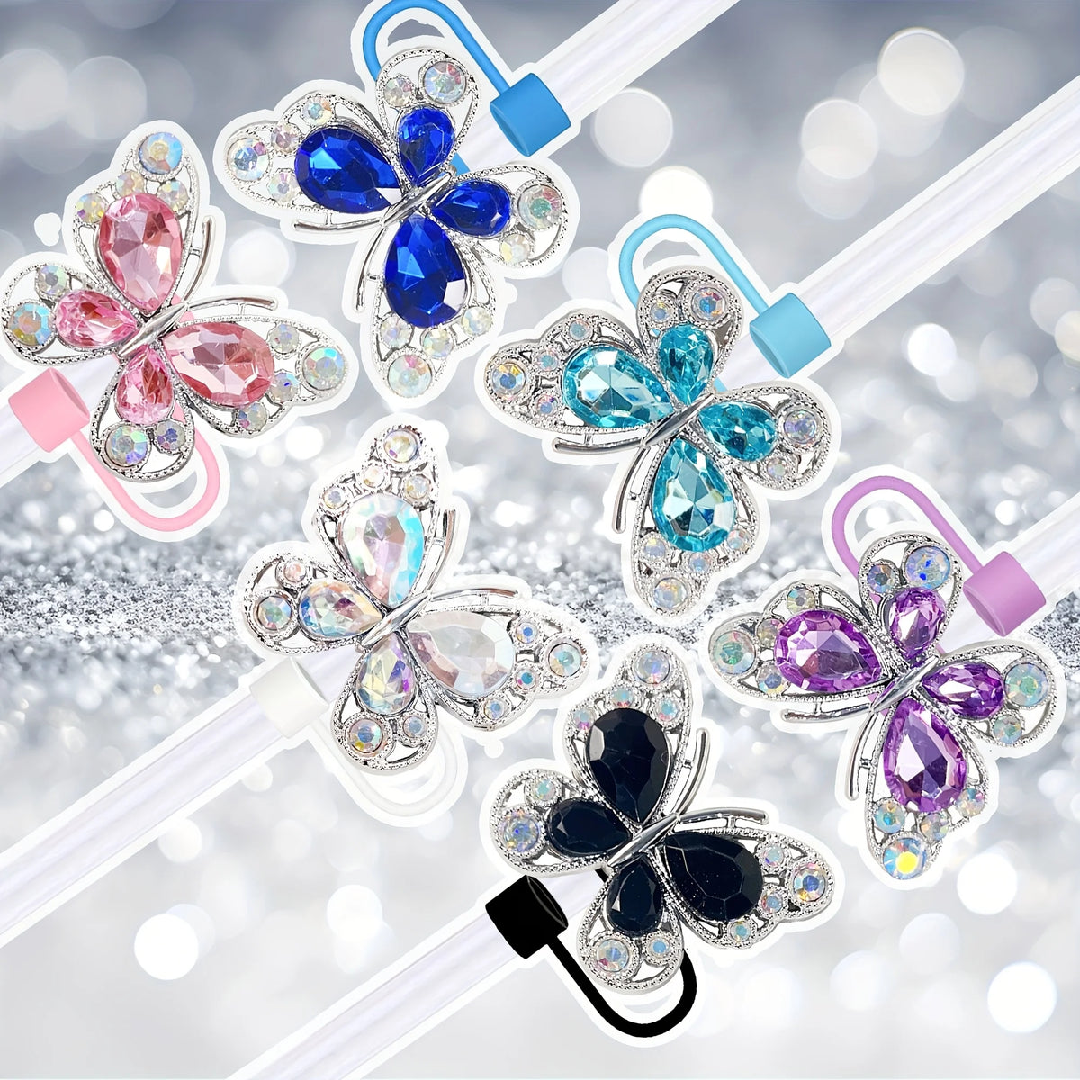 Un set de quatre toppers à paille papillon en silicone de différentes couleurs : rose, bleu, argent et violet.