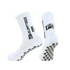 A pair of white men's athletic soccer socks with non-slip grip features black text and a logo on the calf.