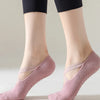 A pair of light pink non-slip yoga and gym socks with silicone grip worn on a person's feet.