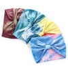 Un ensemble de bandeaux en coton tie-dye dans des tons de violet, bleu, jaune et rose.