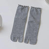 Gray knit crew socks with ruffle cuffs displayed flat on a white surface.