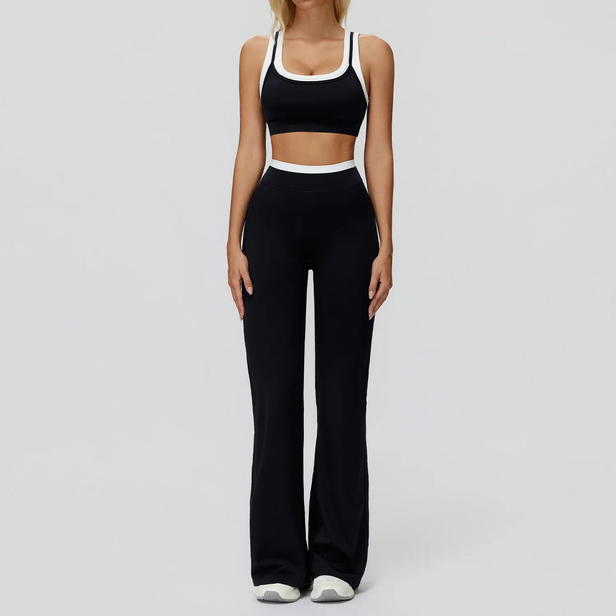 Eine Frau trägt ein schwarz-weißes Yoga- und Sportoutfit-Set.