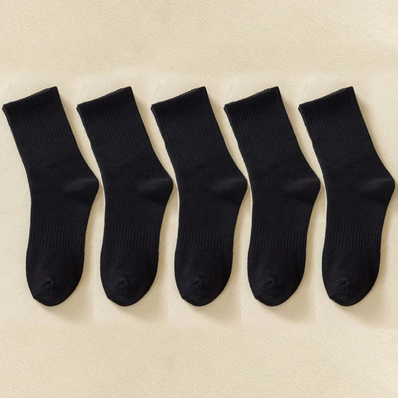 Une rangée de chaussettes en coton-mélange noires pour hommes, posées à plat sur un fond clair.