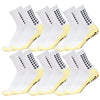 A set of white socks with black dots and yellow grip soles for sports.