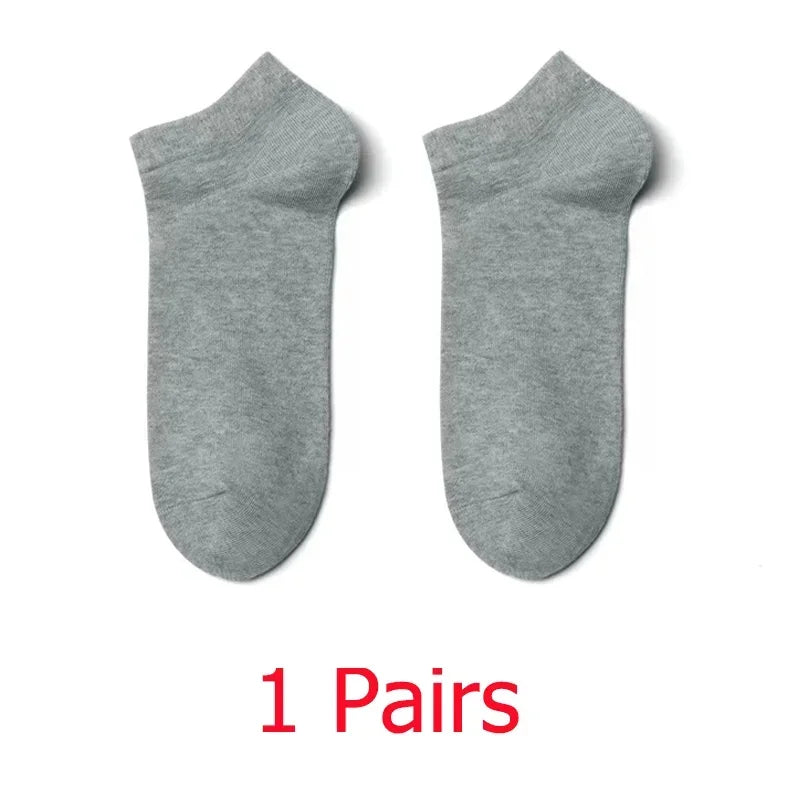 Un par de calcetines unisex de algodón transpirable y color gris claro, extendidos planos.