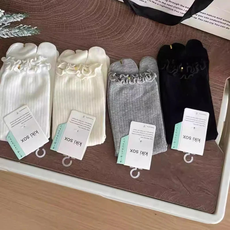 A display of various colored ruffle cuff knit crew socks for women, including white, cream, gray, and black.