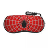 A red spider web patterned pouch with a black spider design and a strap.