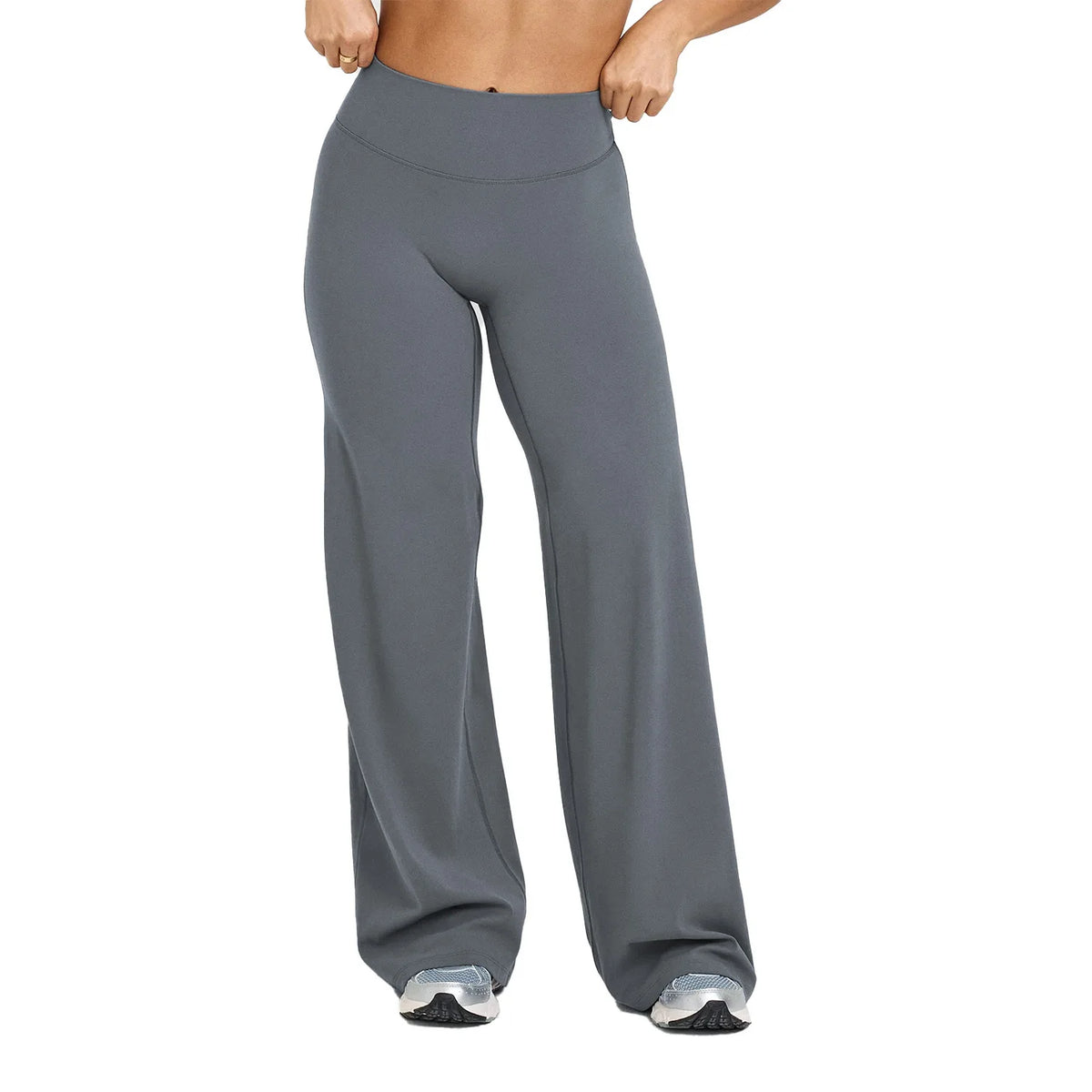 A woman wearing gray high waisted yoga pants with silver accents.