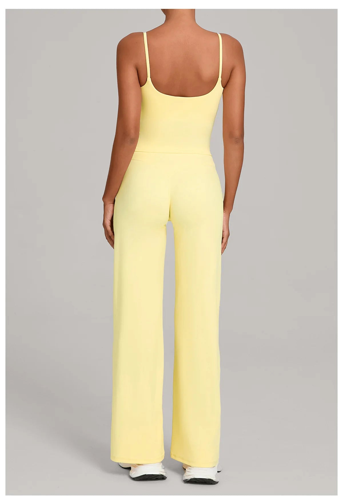 A woman models a yellow high-waist yoga and fitness tracksuit set.