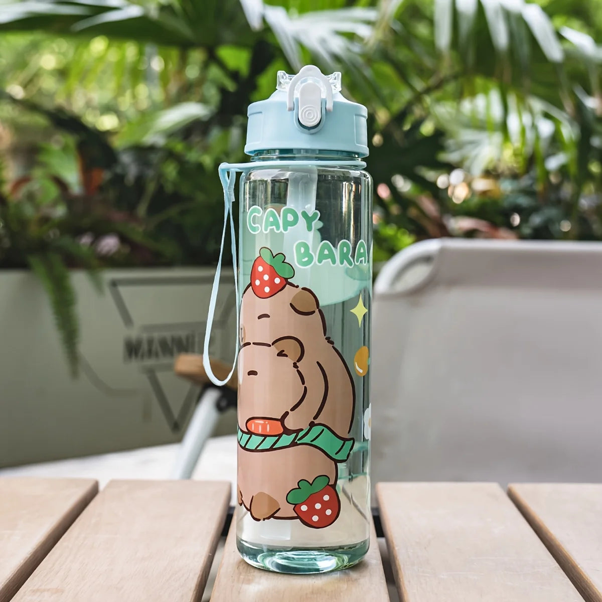 A clear plastic drinking water bottle with a light blue cap and a straw, featuring a cartoon bear and strawberry design.