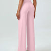 A woman is modeling high waisted pink yoga pants with a light top.