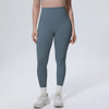 A model wearing high-waisted, full-length, dark blue quick-drying yoga leggings and white athletic shoes.