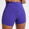 Shorts de yoga compressifs violets taille haute portés par une personne.