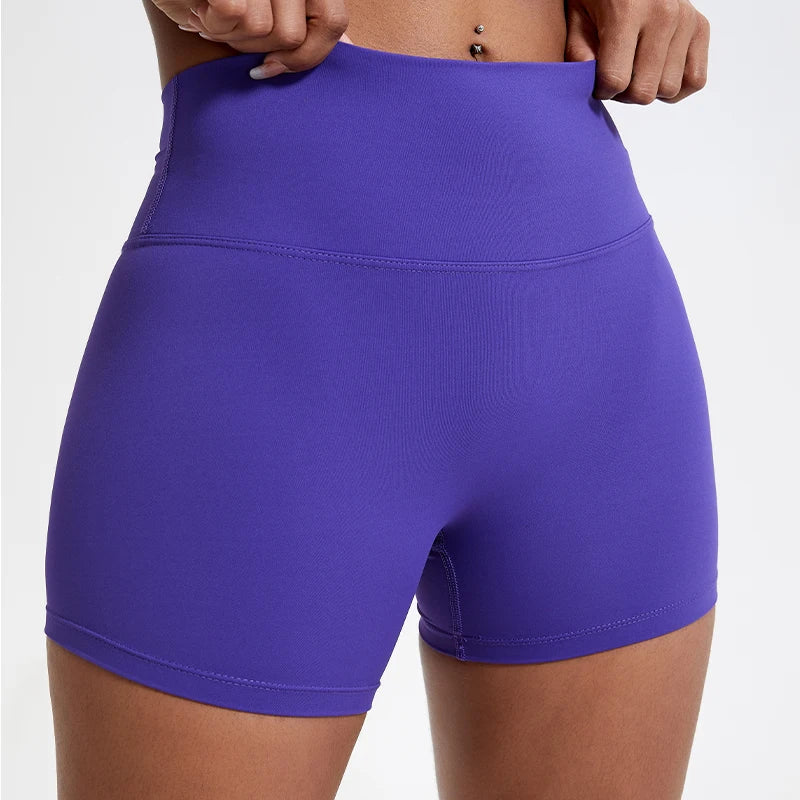 Shorts de yoga compressifs violets taille haute portés par une personne.
