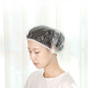 Una mujer lleva un gorro de ducha desechable transparente en su cabello en interiores.