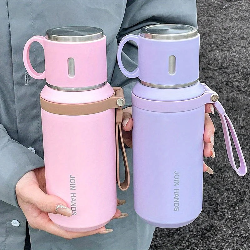 A pink and purple 316 stainless steel insulated water bottle is held in a person's hand.