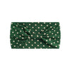 A dark green fabric headband with white polka dots tied in a bow.