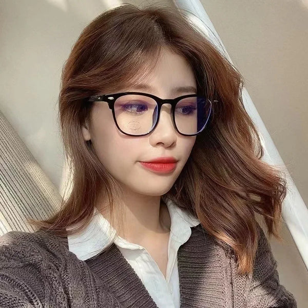 A woman wearing classic clear acetate blue light blocking glasses and a white collared shirt
