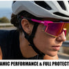 A woman wearing purple sports sunglasses on a sunny outdoor road with a helmet visible.