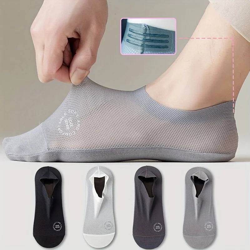 Un paquete de cuatro calcetines de verano transpirables en varios tonos de gris y negro mostrados en un pie.