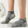 A pair of gray athletic mesh ankle socks with a geometric pattern shown on a person's foot.