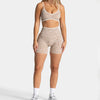 A woman models leopard print seamless yoga shorts in beige and white.