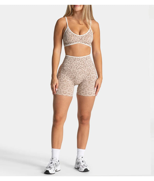 Una mujer modela shorts de yoga sin costuras con estampado de leopardo en beige y blanco.