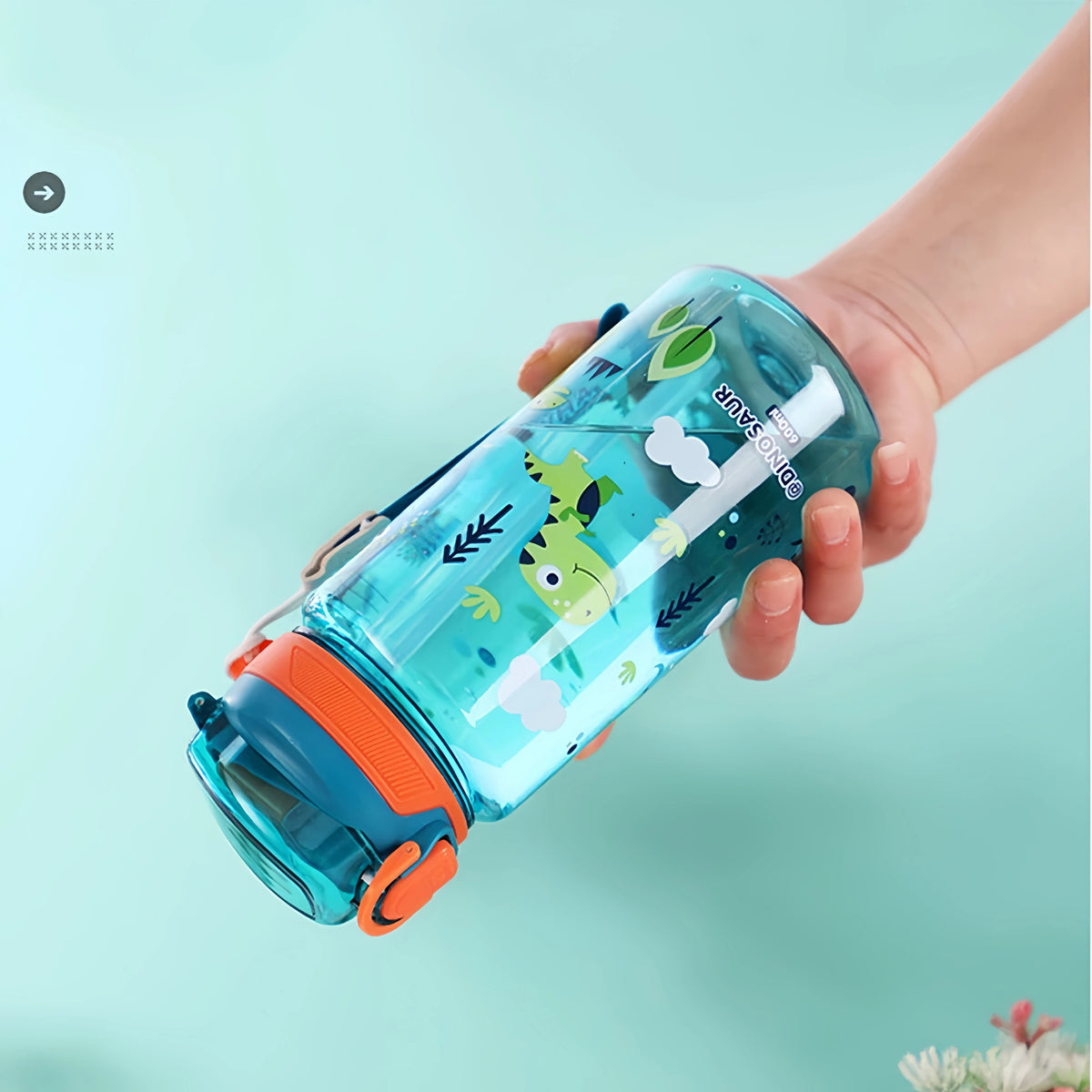 A hand holds a clear blue dinosaur silicone straw water bottle filled with liquid against a light teal background.