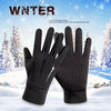 Ein Paar schwarze, thermische Touchscreen-Winterhandschuhe vor einer verschneiten Außenkulisse.