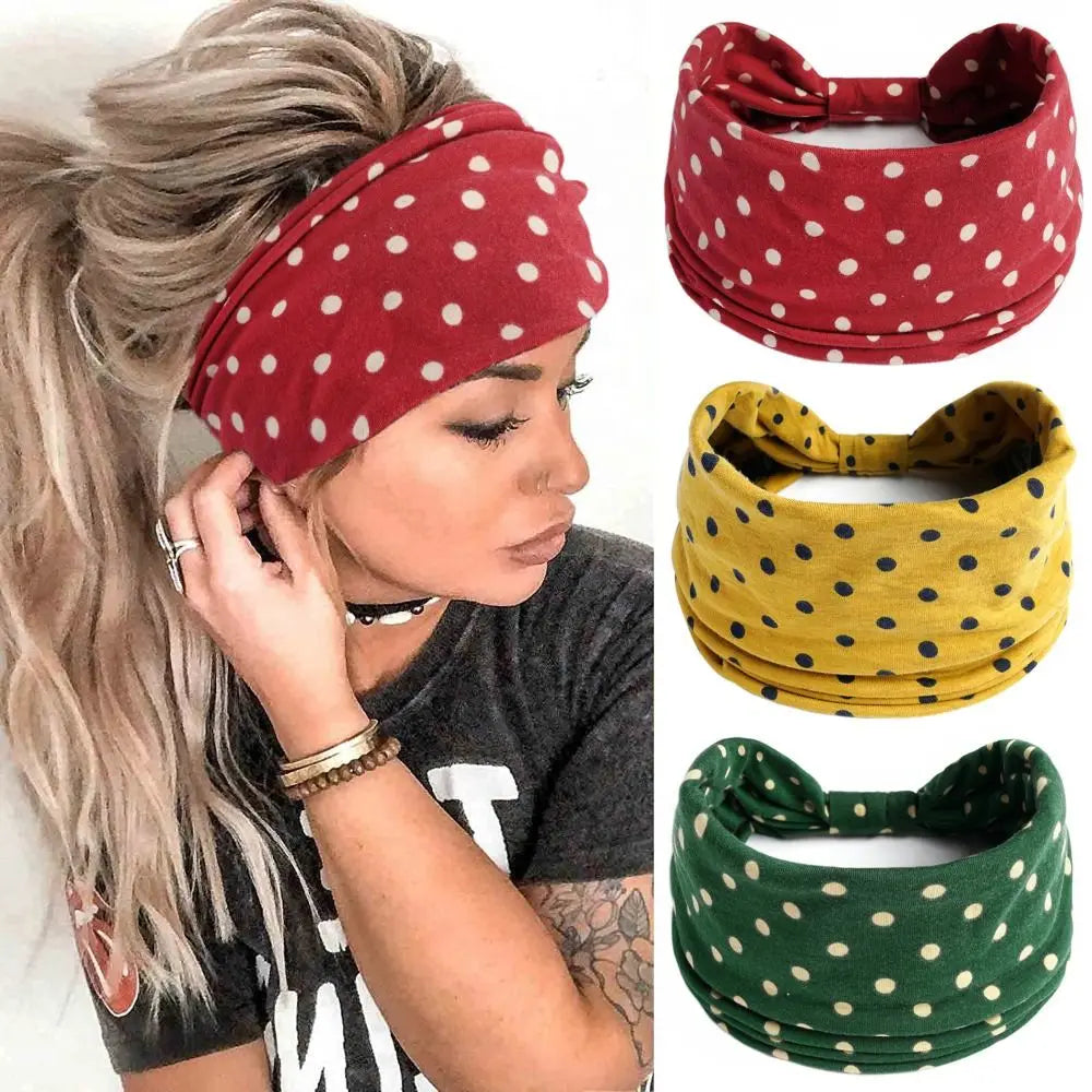 Una mujer modela una cinta para el pelo de lunares rojos en su cabeza, vistiendo una camiseta gris.