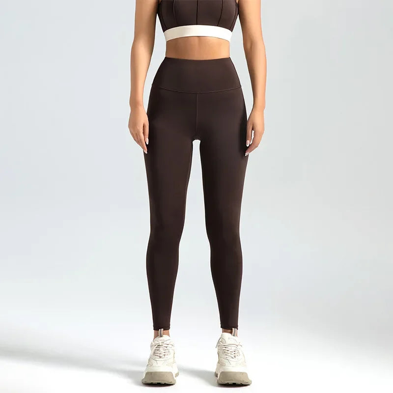 A model wearing seamless high-waist yoga leggings and a matching crop top, standing against a light gray background.