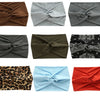 A collection of nine women's elastic sports headbands in various colors and patterns.